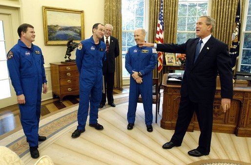 President George W. Bush shares a laugh with members of the International Space Station Expedition 6 Crew during their photo opportunity in the Oval Office Wednesday, Oct. 1, 2003. From left, are, Russian Flight Engineer Nikolai Budarin, Science Officer Donald Pettit, and Commander Kenneth Bowersox. Also pictured in background is NASA Administrator Sean O'Keefe. White House photo by Eric Draper.