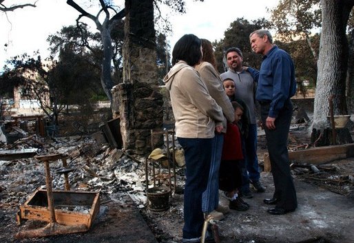 President George W. Bush meets with the Bentley family during a walking tour of the fire-damaged Harbison Canyon community in San Diego, Calif., Tuesday, Nov. 4, 2003. The Bentley family lost their home in last week's wildfires. White House photo by Eric Draper.