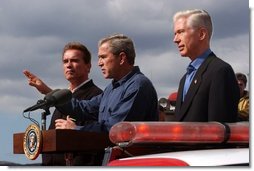 President George W. Bush stands with California Governor-elect Arnold Schwarzenegger, left, and California Governor Gray Davis as he addresses firefighters in El Cajon, Calif., Tuesday, Nov. 4, 2003.  White House photo by Eric Draper