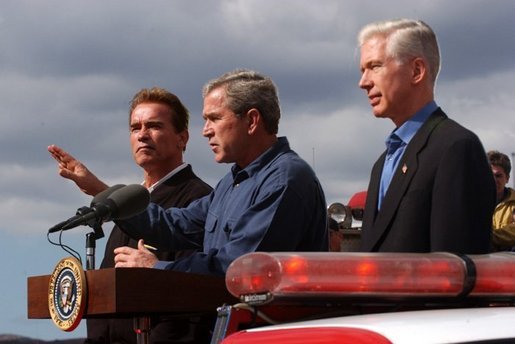 President George W. Bush stands with California Governor-elect Arnold Schwarzenegger, left, and California Governor Gray Davis as he addresses firefighters in El Cajon, Calif., Tuesday, Nov. 4, 2003. White House photo by Eric Draper.