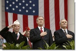President George W. Bush stands with National Commander of the Army and Navy Union David Berger, left, and Secretary of Veterans Affairs Anthony Principi during the Veterans Day ceremonies at Arlington National Cemetery Tuesday, Nov. 11, 2003. "We observe Veterans Day on an anniversary -- not of a great battle or of the beginning of a war, but of a day when war ended and our nation was again at peace," said the President. "Ever since the Armistice of November the 11th, 1918, this has been a day to remember our debt to all who have worn the uniform of the United States."  White House photo by Paul Morse