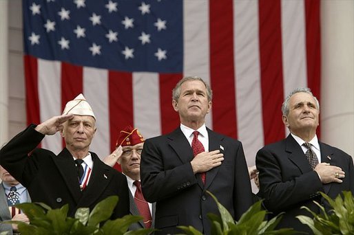 President George W. Bush stands with National Commander of the Army and Navy Union David Berger, left, and Secretary of Veterans Affairs Anthony Principi during the Veterans Day ceremonies at Arlington National Cemetery Tuesday, Nov. 11, 2003. "We observe Veterans Day on an anniversary -- not of a great battle or of the beginning of a war, but of a day when war ended and our nation was again at peace," said the President. "Ever since the Armistice of November the 11th, 1918, this has been a day to remember our debt to all who have worn the uniform of the United States." White House photo by Paul Morse.