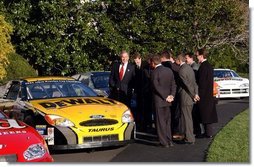 President George W. Bush jokes with NASCAR racers after looking over the stock cars parked on the South Lawn Tuesday, Dec. 2, 2003. "I've hosted champions from many sports here at the White House, this is the first time, however, we ever parked stock cars in the South Lawn," President Bush said.  White House photo by Tina Hager