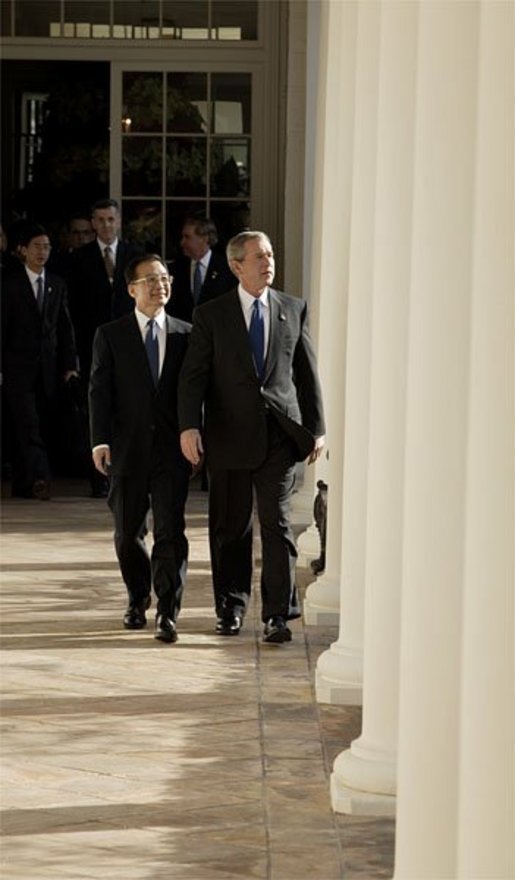 After the Arrival Ceremony, President George W. Bush and Premier Wen Jiabao of China walk along the Rose Garden Colonnade on their way to the Oval Office Tuesday, Dec. 9, 2003. "We're going to have extensive discussions today on a lot of issues," said the President during an Oval Office meeting with the media. "We've just had a very friendly and candid discussion. There's no question in my mind that when China and the United States works closely together we can accomplish a lot of very important objectives." White House photo by Paul Morse