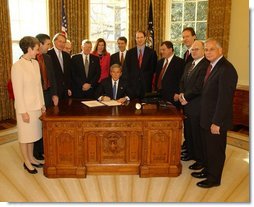 President George W. Bush pauses before signing the Controlling the Non-Solicited Pornography and Marketing Act of 2003, which establishes a framework of administrative, civil and criminal tools to help America’s consumers, businesses and families combat SPAM, in the Oval Office Tuesday, Dec. 16, 2003. Pictured with the President are from left to right: Rep. Heather Wilson, (R, NM); Garry Betty, President and CEO of Earthlink; Rep. Edward Markey (D, MA); Rep. Rick Boucher (D, VA); Sen. Conrad Burns (R, MT); Rep. Melissa Hart (R, PA; Sen. Bill Frist (R, TN); Sen. Ron Wyden (D, OR); Rep. Chris Cannon (R, UT); Jonathan Miller, Chairman and CEO of America Online; Maynard Webb, Chief Operating Officer of eBay; Rep. Gene Green (D, TX).  White House photo by Tina Hager