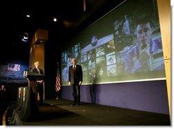 President George W. Bush and NASA Administrator Sean O'Keefe watch as Michael Foale, right, commander of the International Space Station welcomes the President during a live television link from space at NASA headquarters in Washington, D.C., Wednesday, Jan. 14, 2004.  White House photo by Eric Draper