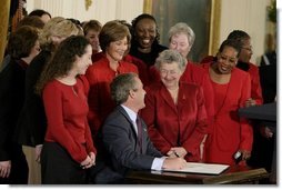 President George W. Bush and Laura Bush laugh with survivors of heart disease as the President signs the American Heart Month proclamation at the White House Monday, Feb. 2, 2004.  White House photo by Paul Morse