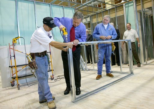 President George W. Bush uses a drill to connect a metal wall frame during a tour of the Carpenters Training Center in Phoenix, Ariz., Friday, March 26, 2004. White House photo by Eric Draper
