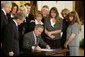 President George W. Bush signs H.R. 1997, the Unborn Victims of Violence Act of 2004, in the East Room Thursday, April 1, 2004. The legislation makes it a crime to harm an unborn child during an assault on a pregnant woman. Pictured are, from left: Sen. Mike DeWine, Sen. Orrin Hatch, Rep. Melissa Hart, Carol Lyons, Buford Lyons, Sharon Rocha, Ron Grantski, Tracy Marciniak-Seavers, Cynthia Warner, and Stephanie Alberts. White House photo by Paul Morse