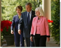 President George W. Bush and First Lady Mrs. Laura Bush walk down the colonnade with Kathleen Mellor of South Kingstown, Rhode Island before presenting her with the 2004 Teacher of the Year award in the Rose Garden of the White House on April 21, 2004.  White House photo by Paul Morse