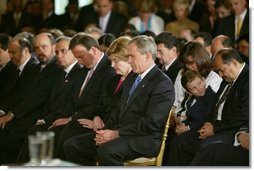 President George W. Bush and Laura Bush bow their heads in prayers during a White House ceremony honoring Cinco de Mayo in the East room Wednesday, May 5, 2004. "Mexican Americans have brought many strengths to our nation: a culture built around faith in God, a deep love for family, a belief that hard work leads to a better life," said the President in his remarks. "Every immigrant who lives by these values makes our country better and makes our future brighter."  White House photo by Paul Morse
