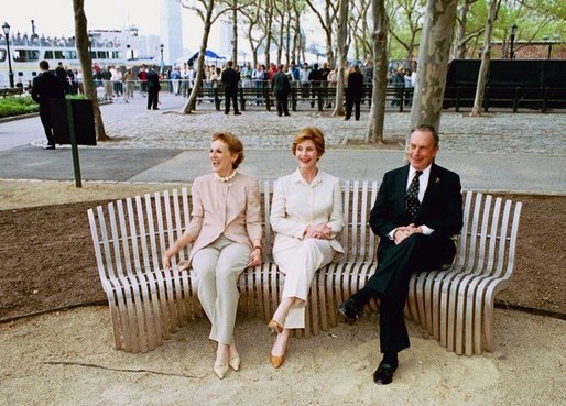 Laura Bush sits on a new park bench with New York City Mayor Michael Bloomberg and The Battery Conservancy Founder and President Warrie Price, left, after the dedication of the 'Gardens of Remembrance' in New York's Battery Park, Monday, May 10, 2004. White House photo by Tina Hager