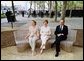 Laura Bush sits on a new park bench with New York City Mayor Michael Bloomberg and The Battery Conservancy Founder and President Warrie Price, left, after the dedication of the 'Gardens of Remembrance' in New York's Battery Park, Monday, May 10, 2004. White House photo by Tina Hager
