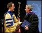 President George W. Bush is congratulated upon receiving an honorary doctorate degree during the commencement ceremonies for Concordia University near Milwaukee, Wis., Friday, May 14, 2004. White House photo by Paul Morse.
