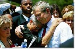 President George W. Bush hugs a woman attending the Annual Peace Officers' Memorial Service at the U.S. Capitol in Washington, D.C., Saturday, May 15, 2004. "I also thank all the family members who have come to Washington for this service. For each of you, there is a name on the National Law Enforcement Officers Memorial that will always stand apart. You feel the hurt of loss and separation, but I hope that you don't feel alone," said the President.  White House photo by Paul Morse
