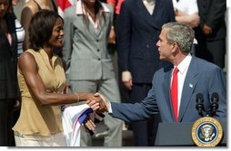President George W. Bush greets Detroit Shock player Swin Cash during a photo opportunity with the 2003 WNBA champions in the Rose Garden on May 24, 2004.  White House photo by Paul Morse