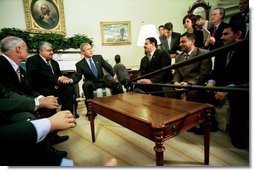 President George W. Bush talks with the press during an Oval Office meeting with several Iraqis who receive medical care in the United States Tuesday, May 25, 2004. "I'm honored to shake the hand of a brave Iraqi citizen who had his hand cut off by Saddam Hussein," said the President. "I'm with six other Iraqi citizens, as well, who suffered the same fate. They are examples of the brutality of the tyrant."  White House photo by Eric Draper