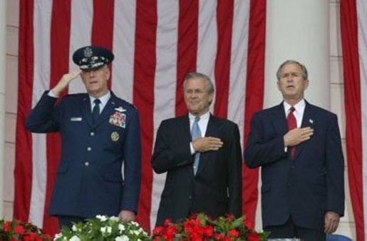 President George W. Bush, Secretary of Defense Donald Rumsfeld and Chairman of the Joint Chiefs of Staff General Richard B. Meyers look on as the National Anthem is played during Memorial Day commemorative ceremonies at Arlington National Cemetery in Arlington, Virginia Monday May 31, 2004. White House photo by Joyce Naltchayan.