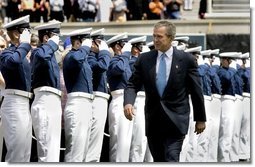 President George W. Bush walks to the stage while saluted by Air Force Cadets during his introduction at the United States Air Force Academy Graduation Ceremony in Colorado Springs, Colorado, June 2, 2004.  White House photo by Eric Draper