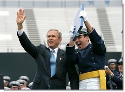 President George W. Bush celebrates with a graduating Air Force Cadet during the United States Air Force Academy Graduation Ceremony in Colorado Springs, Colorado, June 2, 2004.  White House photo by Eric Draper