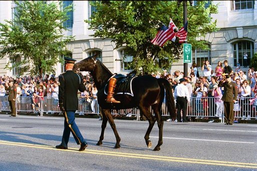 A riderless black horse, with a pair of former President Ronald Reagan's favorite boots turned backward in the stirrups, symbolising the death of a military leader, follows a horse-drawn caisson carrying his casket, Wednesday, June 9, 2004. White House photo by Joyce Naltchayan.