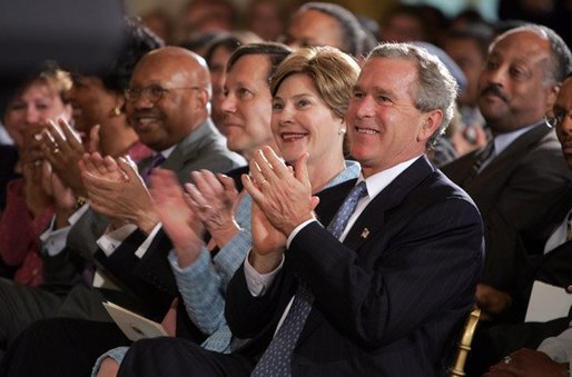 President George W. Bush and Mrs. Laura Bush applaud the performances of jazz musicians during a reception for Black Music Month in the East Room of the White House on June 22, 2004. White House photo by Paul Morse