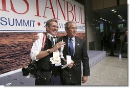 After participating in the official group photo of NATO leaders, President George W. Bush grabs Reuters photographer Larry Downing for a quick photo op of his own during the NATO Summit at the Istanbul Convention and Exhibition Center in Turkey, Monday, June 28, 2004.