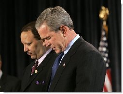 President George W. Bush joins Marc Morial, President of the National Urban League, in prayer on stage before delivering remarks in Detroit, Mich., Friday, July 23, 2004.  White House photo by Eric Draper