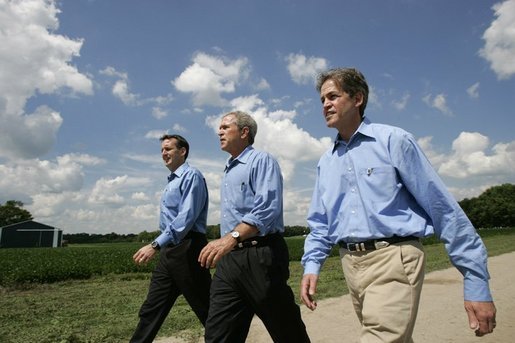 President George W. Bush walks with Minnesota Governor Tom Pawlenty, left, and Sen. Norm Coleman during a visit to the Katzenmeyer family farm in Le Sueur, Minn., Wednesday, Aug. 4, 2004. White House photo by Eric Draper.