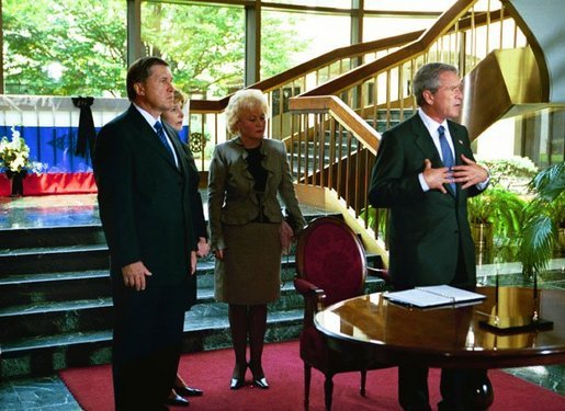 After signing a condolence book for the victims of the recently attacked school in Beslan, Russia, President George W. Bush addresses the media as Ambassador Yuri Ushakov, far left, Laura Bush, and the Ambassador's wife, Svetlana Ushakova, listen at the Russian Embassy in Washington, D.C., Sept. 12, 2004. "I'm here to express my country's heart-felt sympathies for the victims and the families who suffered at the hands of the evil terrorists. The United States stands side-by-side with Russia as we fight off terrorism, as we stand shoulder-to-shoulder to make the world a more peaceful place and a free place," said President Bush. White House photo by Paul Morse.