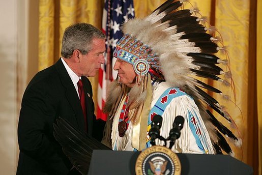 President George W. Bush greets Sen. Benjamin Nighthorse Campbell, R-Colo., during a ceremony marking the opening of the National Museum of the American Indian in the East Room Thursday, Sept. 23, 2004. White House photo by Paul Morse