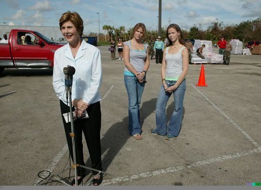 Laura Bush speaks to reporters after working with volunteers at the Indian River County Distribution Center as her daughters, Jenna and Barbara stand with her in Vero Beach, Fla., Friday, October 1, 2004. White House photo by Joyce Naltchayan.