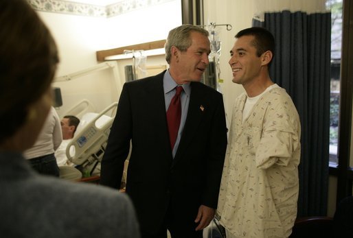 President George W. Bush talks with U.S. Army Spc. Kenneth Lukes of Fort Atkinson, Iowa, during a visit to Walter Reed Army Medical Center in Washington, D.C., Tuesday, Nov. 9, 2004. White House photo by Eric Draper.