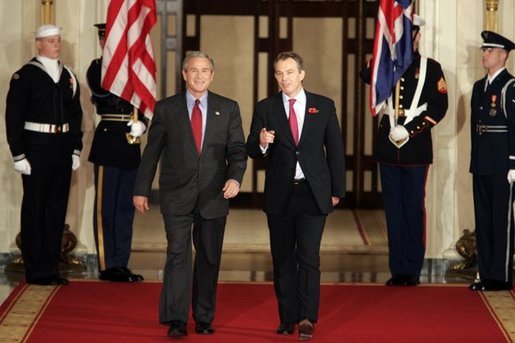 President George W. Bush and British Prime Minister Tony Blair walk down the Cross Hall of the White House before their press conference on Friday November 12, 2004. White House photo by Paul Morse