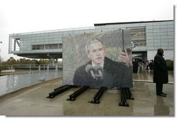 As pictured on an outdoor video screen, President George W. Bush addresses attendees during the dedication of former President Bill Clinton’s Presidential Center and Park in Little Rock, Ark., Nov. 18, 2004. "He was a tireless champion of peace in the Middle East. He used American power in the Balkans to confront aggression and halt ethnic cleansing. And in all his actions and decisions, the American people sensed a deep empathy for the poor and the powerless," said President Bush.  White House photo by Eric Draper