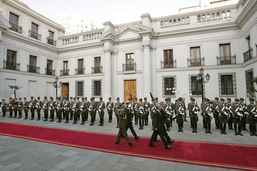 President George W. Bush walks with President Ricardo Lagos of Chile past a unit of Carabineros at the La Moneda Presidential Palace upon arrival for a meeting and private dinner in Santiago, Chile, Nov. 21, 2004. White House photo by Paul Morse