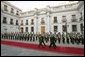 President George W. Bush walks with President Ricardo Lagos of Chile past a unit of Carabineros at the La Moneda Presidential Palace upon arrival for a meeting and private dinner in Santiago, Chile, Nov. 21, 2004. White House photo by Paul Morse