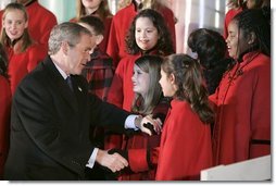 President George W. Bush greets members of the West Tennessee Youth Chorus during the National Christmas Tree lighting ceremony on the Ellipse in front of the White House Dec. 2, 2004.  White House photo by Paul Morse