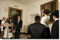 President George W. Bush and Laura Bush watch the lighting of the Menorah at the White House Thursday, Dec. 9, 2004. "We are honored to celebrate the miracle of Hanukkah in the White House this evening," said the President.  White House photo by Paul Morse