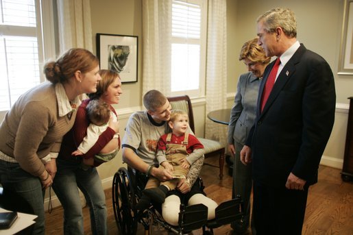 President George W. Bush and Laura Bush talk with U.S. Army Sgt. Dale Beatty of Statesville, N.C., and, from left, sister-in-law Wendolyn Summers, wife Belinda Beatty, son Lucas, 6 months old, and son Dustin, 2 years old, during a visit to the Fisher House at Walter Reed Army Medical Center in Washington, D.C., Tuesday, Dec. 21, 2004. President Bush presented Sgt. Beatty The Purple Heart for injuries he sustained while serving in Operation Iraqi Freedom. White House photo by Paul Morse