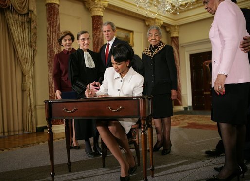 Secretary of State Dr. Condoleezza Rice signs official papers Friday, Jan. 28, 2005, after receiving the oath of office during her ceremonial swearing in at the Department of State. Watching on are, from left, Laura Bush, Justice Ruth Bader Ginsburg, President George W. Bush and an unidentified family member. White House photo by Eric Draper