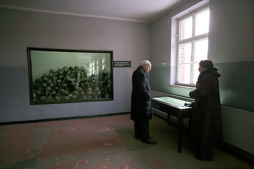 Standing in a room formerly used as barracks for Nazi prisoners, a museum guide explains to Vice President Dick Cheney about the atrocities committed there at the Auschwitz-1 Nazi concentration camp, near Krakow, Poland, Friday, Jan. 28, 2005. The window at left shows a display of empty cans of Zyklon-B gas used against former prisoners. Vice President Cheney was there to take part in ceremonies commemorating the 60th Anniversary of the liberation of the Auschwitz camps. White House photo by David Bohrer