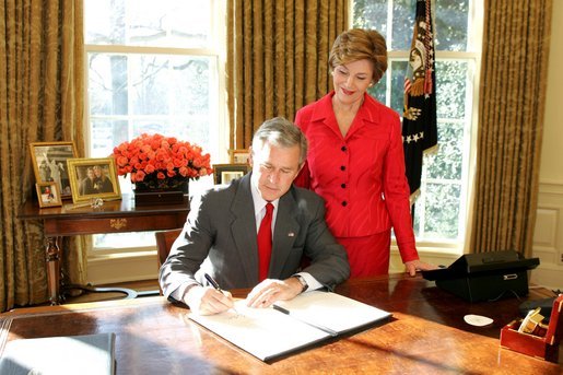 With Laura Bush looking on, President George W. Bush signs a proclamation designating February as American Heart Month in the Oval Office, Feb. 1, 2005. The proclamation encourages awareness of factors leading to heart disease such as smoking, high cholesterol, lack of exercise, obesity and diabetes. White House photo by Susan Sterner