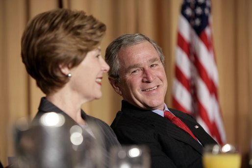 President George W. Bush and Laura Bush laugh during the National Prayer Breakfast in Washington, D.C., Thursday, Feb. 3, 2005. White House photo by Paul Morse