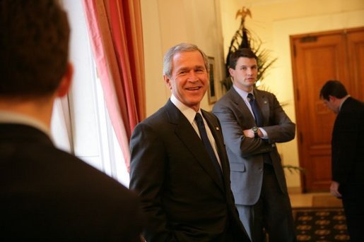 President George W. Bush speaks with staff before a meeting Tuesday, Feb. 22, 2005, at the Ambassador's Residence in Brussels. White House photo by Eric Draper