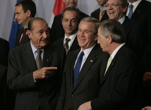 President George W. Bush talks with French President Jacques Chirac, left, and European Union President Jean-Claude Juncker as world leaders take their places for the official NATO group photo in Brussels Tuesday, Feb. 22, 2005. White House photo by Eric Draper