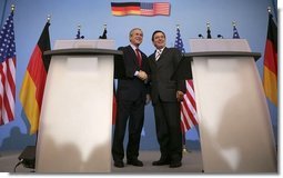 President George W. Bush shakes hands with German Chancellor Gerhard Schroeder during a Feb. 23, 2005, joint press conference at the Electoral Palace in Mainz, Germany.   White House photo by Eric Draper