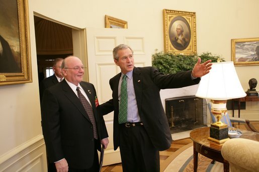 President George W. Bush talks with U.S. Army veteran Tom Cadmus, the National Commander of the American Legion, in the Oval Office Thursday, March 17, 2005. White House photo by Eric Draper