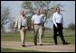 Hosting a lunch and tour at his ranch, President George W. Bush waves to the press while walking with Canadian Prime Minister Paul Martin, left, and Mexican President Vicente Fox in Crawford, Texas, March 23, 2005. White House photo by Eric Draper White House photo by Eric Draper