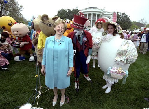 Accompanied by all sorts of story book characters, Lynne Cheney the host of the 2003 White House Easter Egg Roll, addresses the media on the South Lawn Monday, April 21, 2003. "But most of all, we are proud of all of you, the men and women who serve our country, who keep our country free," said Mrs. Cheney in her opening remarks welcoming U.S. military families to the event. File Photo. White House photo by David Bohrer